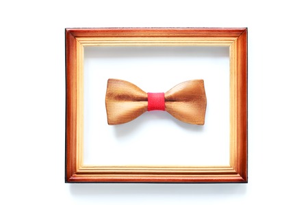 Wooden bowtie in wood frame isolated on white. Hipster, unique, initiative, think different, success storyの写真素材