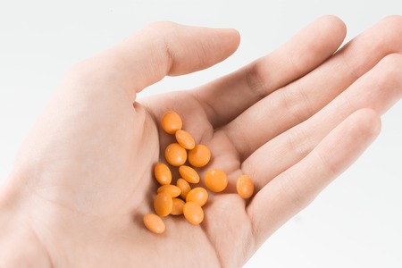 Woman hand holding orange pills before doing suicide.の写真素材