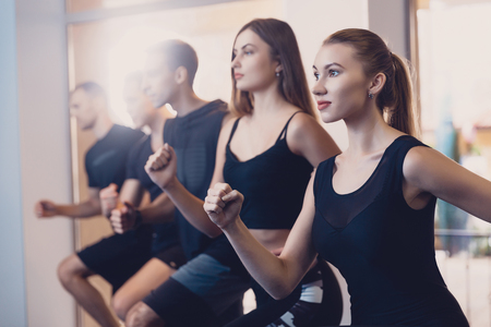 Group men and women performs a physical exercise. Joint exercise of men and women. Exercise to...