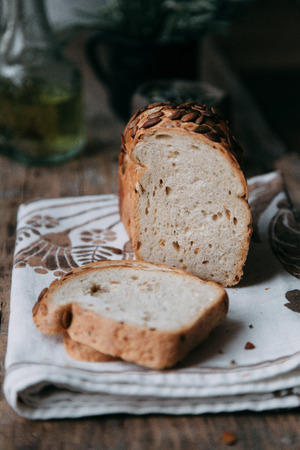 Sliced bread with butter on wooden background and the scattered seeds.