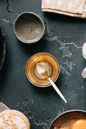 The process of cooking pancakes on a black background and set of ingredientsの写真素材