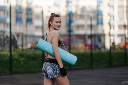 sporting a young girl in the gym and the stadium, warming up before exercise and listening to musicの写真素材