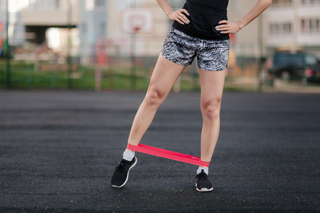 sporting a young girl in the gym and the stadium, warming up before exercise and listening to musicの写真素材