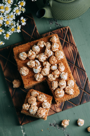 honey on a wooden Board with sweet popcorn. Composition with flowers on the table in the dark keyの写真素材