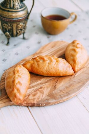 homemade pastries with fillings of potatoes, cabbage and fish, in the composition on a textured backgroundの写真素材