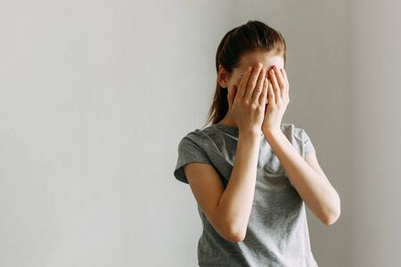 The girl covers her face with her hands and cries. Stop domestic violence against women.の写真素材
