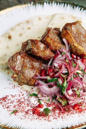 Restaurant dish on a wooden background. Azerbaijani shish kebab and grilled ribs.の写真素材
