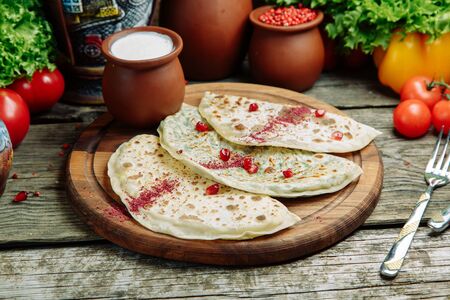 Azerbaijani cuisine and serving dishes in the restaurant. Chebureks with sauce on a wooden Board. の写真素材
