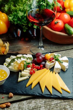 Set of cheese with honey and nuts. Slicing cheeses on a stone Board. の写真素材