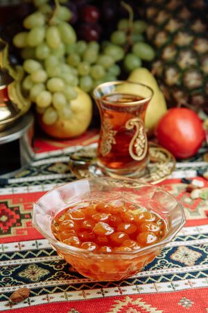 Jam of berries and ripe fruit. Restaurant dish with vegetable decor on a wooden background. Jam in a glass saucer. の写真素材