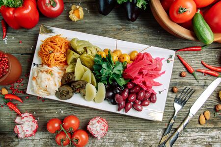 Azerbaijani restaurant dish with vegetable decor on a wooden background. Sliced vegetables and herbs on a plate.の写真素材