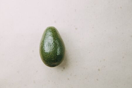 Avocado on a light background in a section. Natural vegetarian food. Ripe avocado in your hands. の写真素材