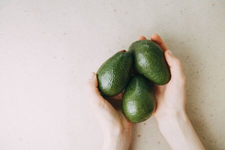 Avocado on a light background in a section. Natural vegetarian food. Ripe avocado in your hands. の写真素材