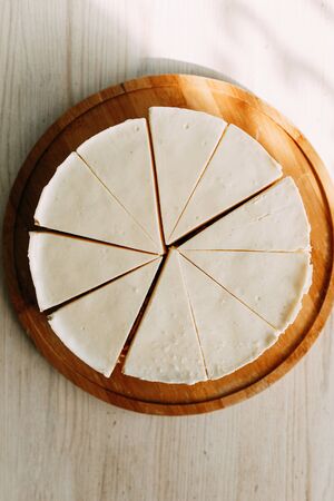  Cake cut into slices on a short dough. Cream cheesecake on a wooden Board.の写真素材