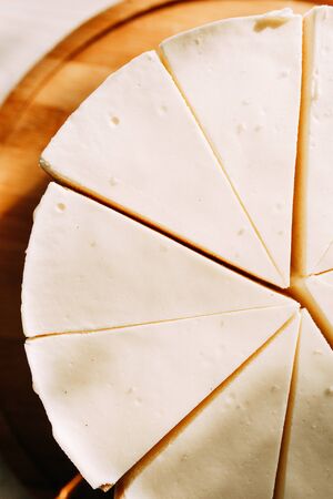  Cake cut into slices on a short dough. Cream cheesecake on a wooden Board.の写真素材