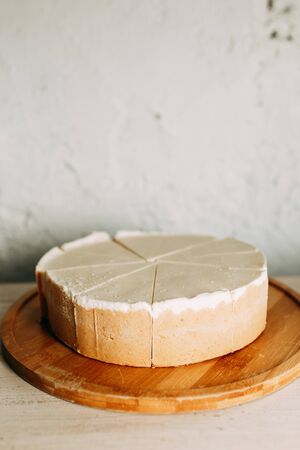  Cake cut into slices on a short dough. Cream cheesecake on a wooden Board.の写真素材