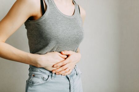 Poisoning and abdominal pain. The zone of injury, the image on a blank background. A spasm in the girl's stomach. の写真素材