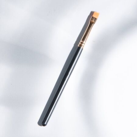 Light background with highlights for the site. A tool for a makeup artist. Makeup brush. Black plastic eyebrow brush. の写真素材