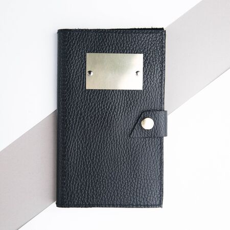 Hands with the packaging for makeup brushes. Black leather case on white background.の写真素材