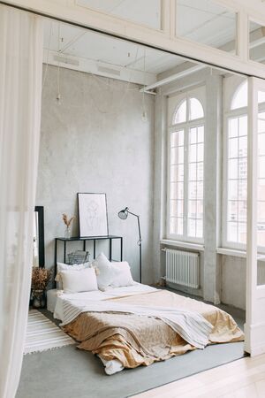 Bright photo Studio with a bed and a window. Stylish modern loft interior. の写真素材