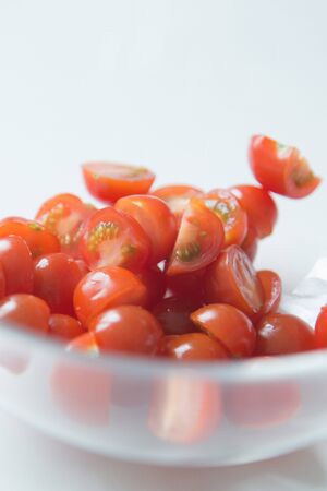  A handful of sliced tomatoes for the salad. Ripe cherry tomatoes in a bowl.の写真素材