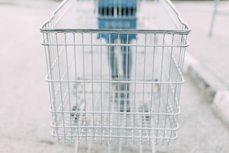 Food basket and the girl's hands. Trolley for shopping products in the supermarket. の写真素材