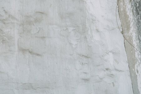 Textured wall of the old house. The texture of old cracked concrete with paint. 
