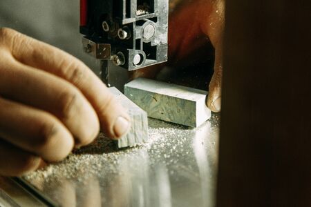 Cutting parts made of wood on the bandsaw. Wood processing workshop.の写真素材