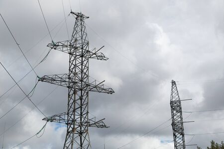Poles of power lines between cities. Power line support against the sky. の写真素材