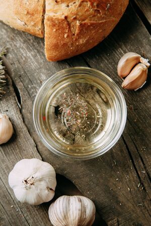 Baking on a wooden background. Fresh sliced white bread. Oil and olives with spices. の写真素材