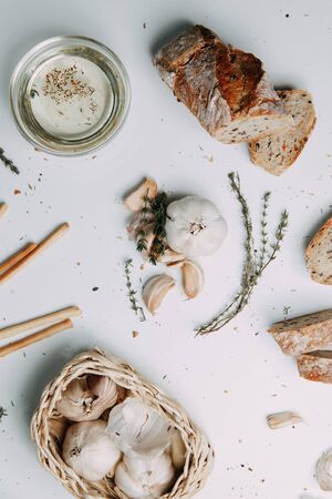  Flatley layout for cooking. Garlic cloves on a white background. Peeled garlic with salt, oil and...
