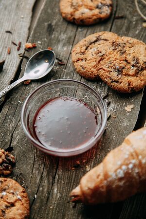 Baking on a Flatley wooden background. Oatmeal cookies with jam. Croissants with raspberry jam. 