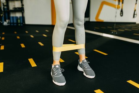 Flexibility exercises on a black background. Stretching in a dark room on a rug. Beautiful girl athlete on the floor. の写真素材