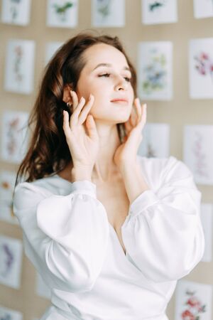 Portrait of the bride. Morning of the bride in a boudoir dress. Bright interior of the Studio with postcards.の写真素材