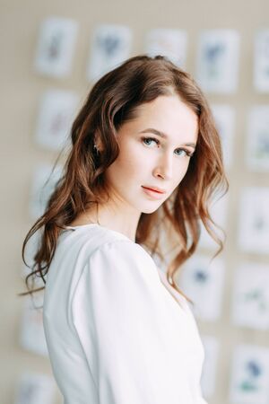 Portrait of the bride. Morning of the bride in a boudoir dress. Bright interior of the Studio with postcards.の写真素材