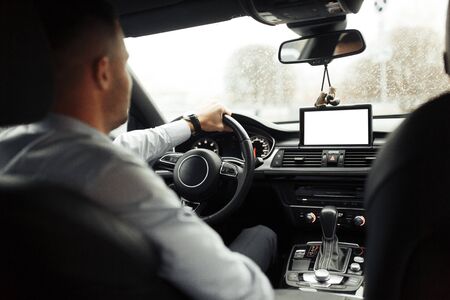 Conversations and phone calls, negotiations. Portrait of a young successful man in the car. 