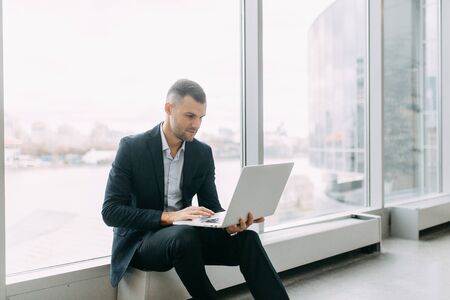 Office work, business situation. A young business man with a laptop in his hands.の写真素材