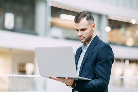 Office work, business situation. A young business man with a laptop in his hands.の写真素材