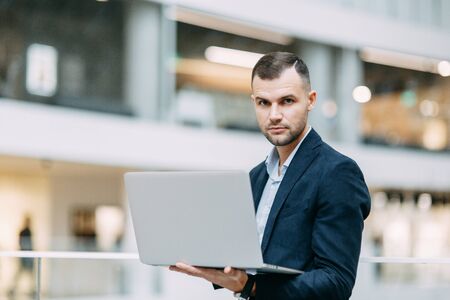 Office work, business situation. A young business man with a laptop in his hands.の写真素材