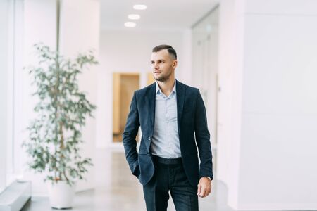 Walking around the business center. Portrait of a young successful man in motion.の写真素材