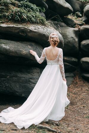 Wedding in the European style in nature. Bride in a white dress on the rocks. の写真素材