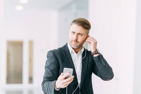 A man listens to music on his way to work. Light Office or shopping Mall.の写真素材
