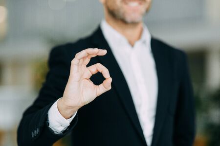 Hands of a businessman to design with a neutral photon. Okay, high five, palms and a successful man.