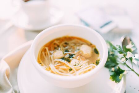 Soup with greens, mushrooms and noodles with chicken. Restaurant dishes with a beautiful serving.の写真素材