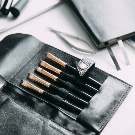 Brush brow and makeup artist in the set. Black and white sets. Flatley layout for blogger. Minimalism on the table, gold brushesの写真素材