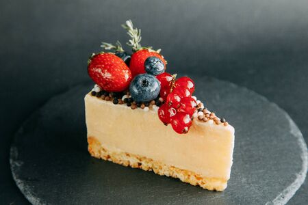 Berry Cakes on a black stone background, author's desserts and serving. Chocolate, berries and cream. The design for the websiteの写真素材
