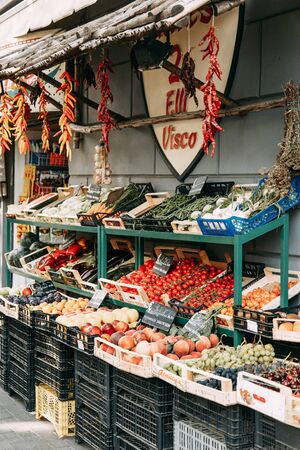 A street market in Italy. Fruit and fish on the counter. Fresh vegetables, close perspective. Fish products, shrimp and mussels with ice.の写真素材