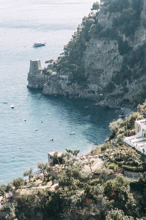 The coast of Positano, Amalfi in Italy. Panorama of the evening city and the streets with shops and cafes. Houses by the sea and the beach. Ancient architecture and temples. View from a postcard on topの写真素材