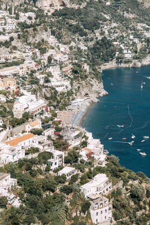 The coast of Positano, Amalfi in Italy. Panorama of the evening city and the streets with shops and cafes. Houses by the sea and the beach. Ancient architecture and temples. View from a postcard on topの写真素材