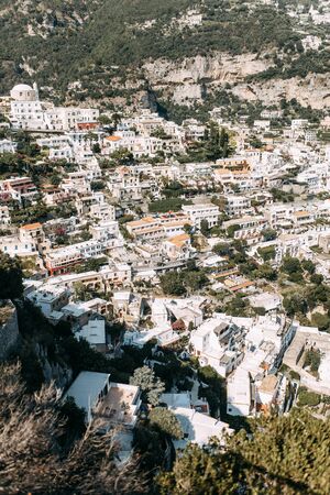 The coast of Positano, Amalfi in Italy. Panorama of the evening city and the streets with shops and cafes. Houses by the sea and the beach. Ancient architecture and temples. View from a postcard on topの写真素材